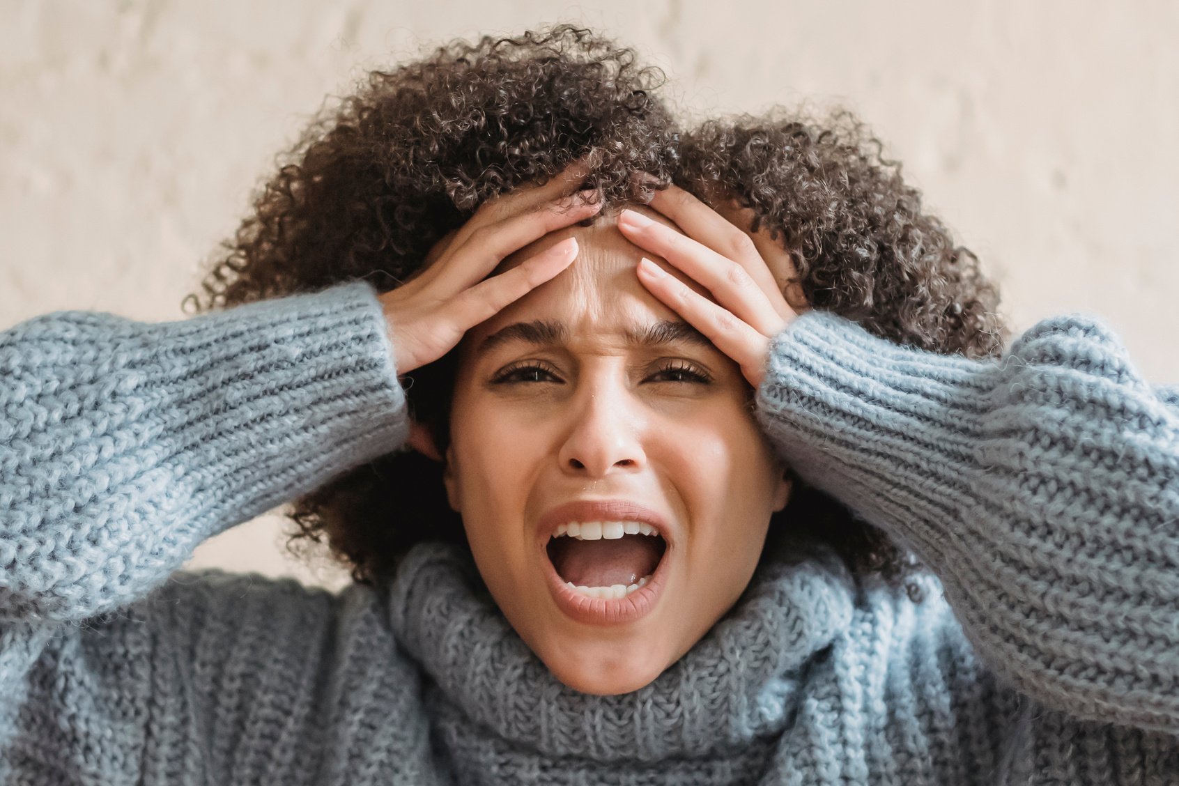 Emotional black woman yelling and touching head