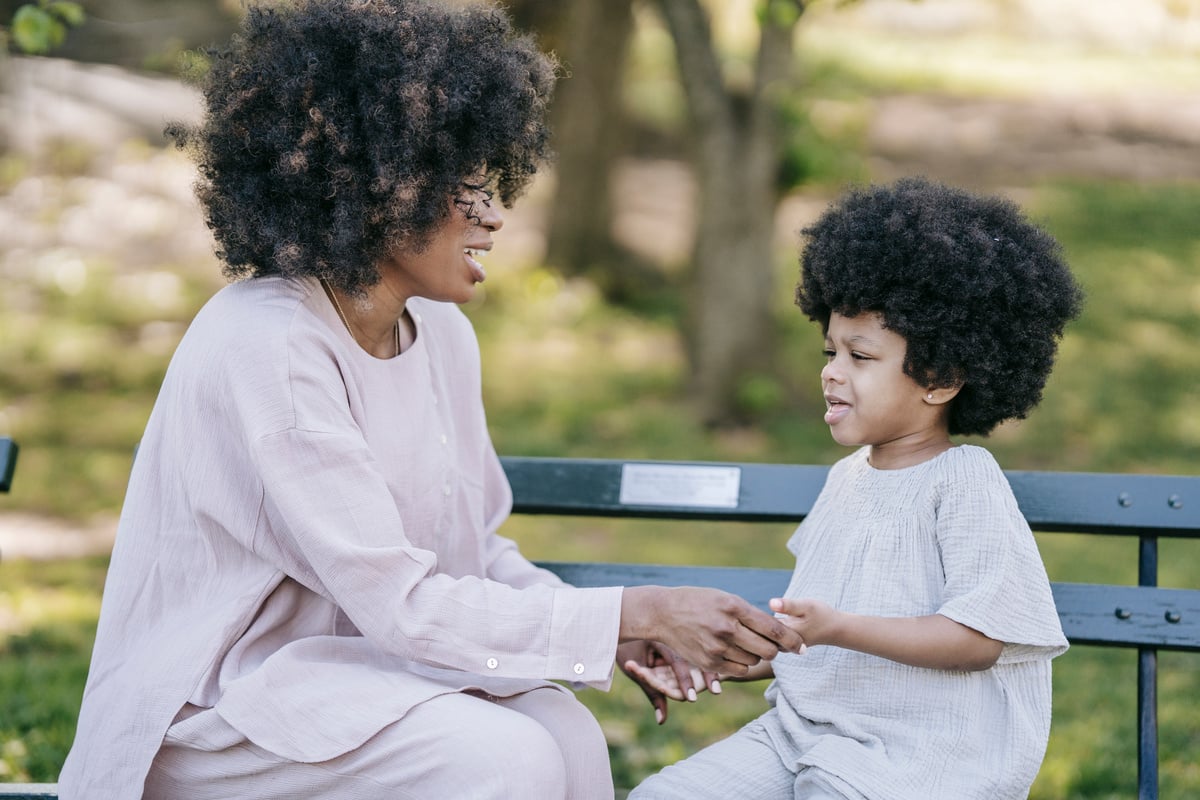 A Woman Sitting on a Wooden Bench with her Daughter